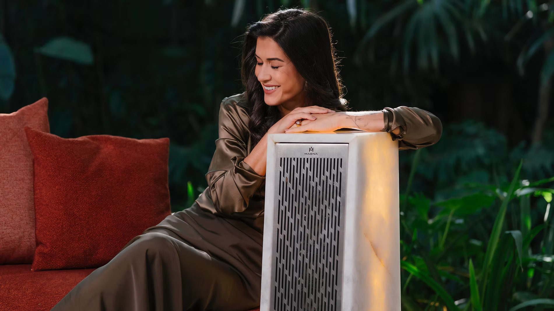 Femeie așezată pe boxa de exterior Magna Audio Rock F66 cu iluminat integrat, o soluție premium de sonorizare outdoor cu design sculptural pentru terase, grădini și spații de lux.